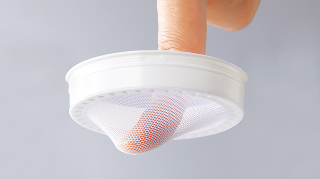 Checking the elasticity of the inner lid by pressing it with a finger against the mesh